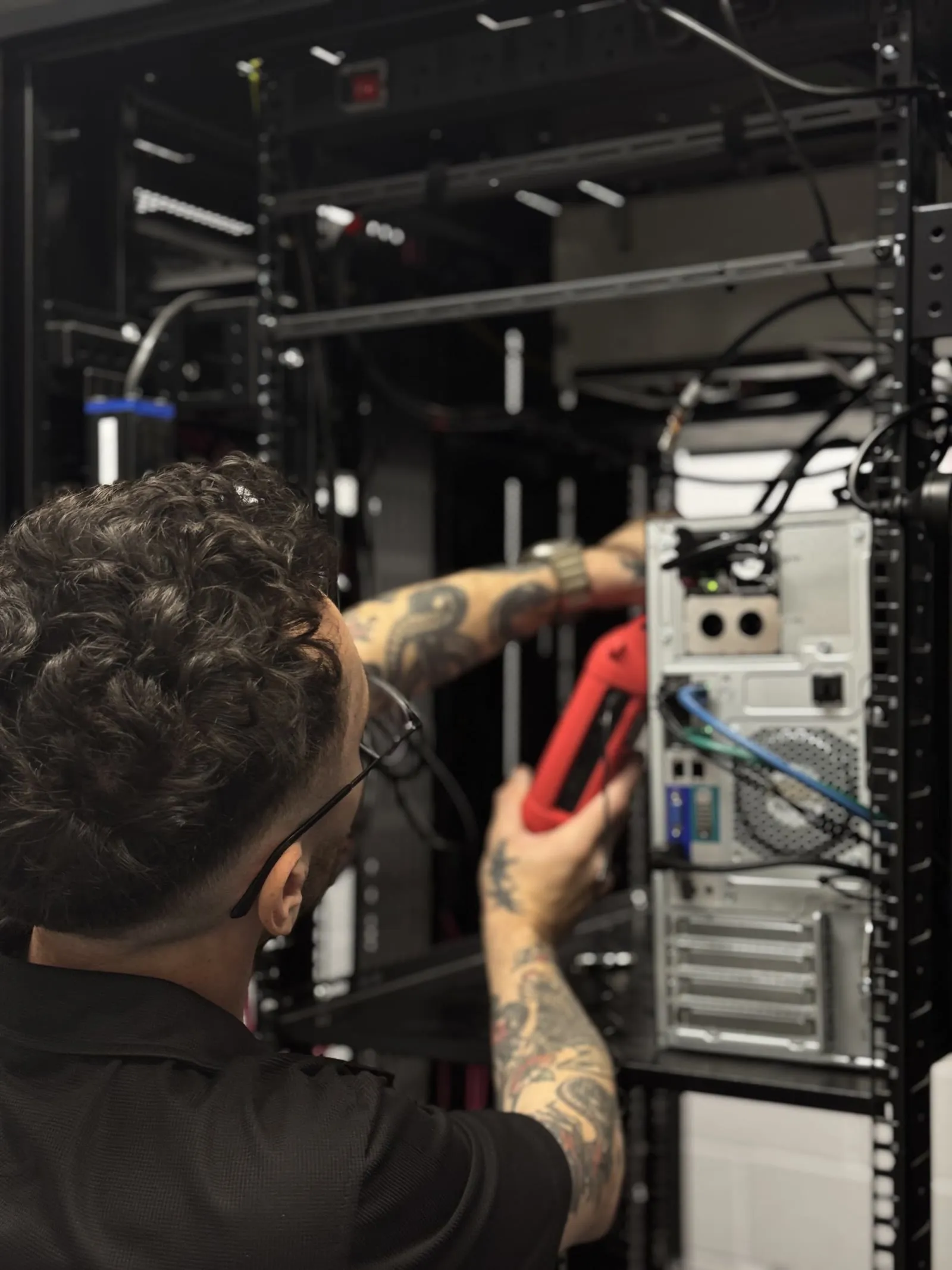 A Focus AV technician taking a signal measurement at the head-end rack with a handheld test meter