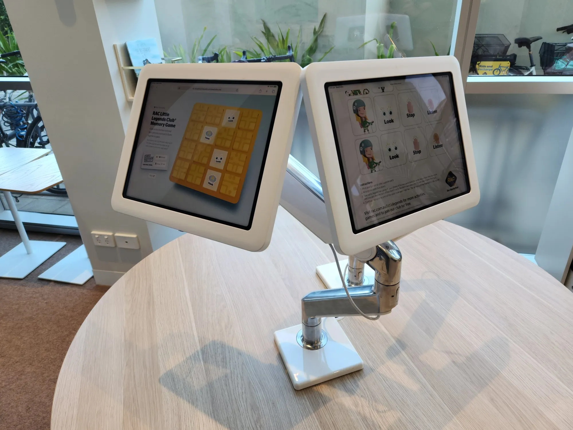 Two touch panels on monitor arms mounted to a timber desk