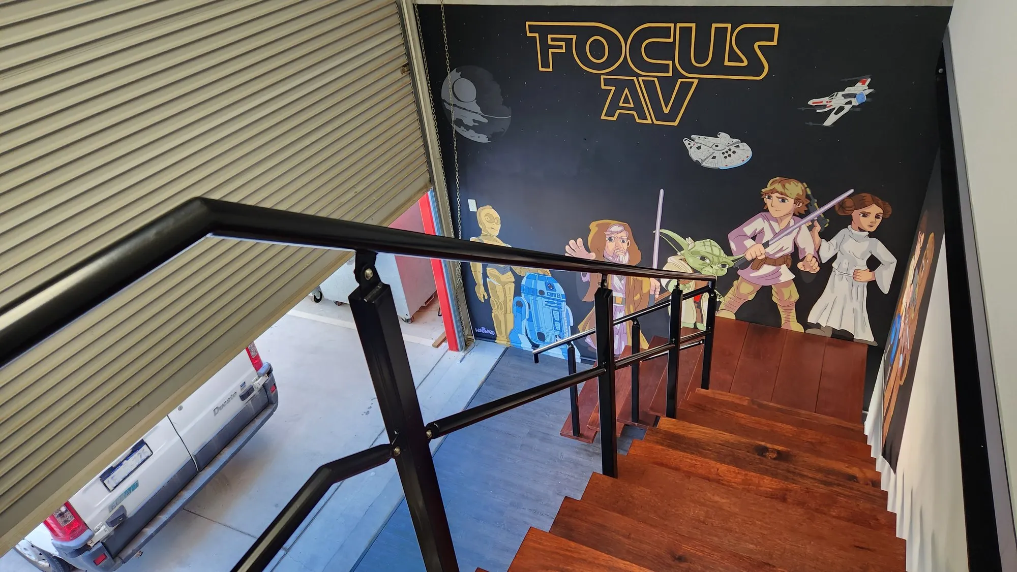 The Focus AV workshop stairwell with its hand-painted Star Wars mural, the van visible through the door
