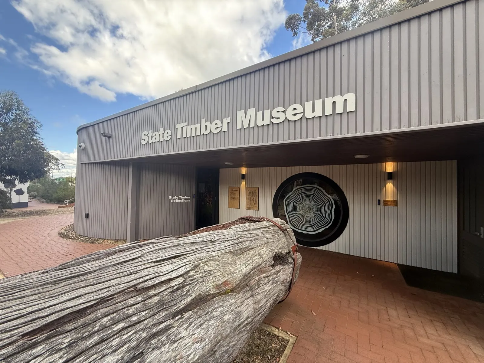 The State Timber Museum building at Manjimup Heritage Park, a giant tree-ring window set beside the entry