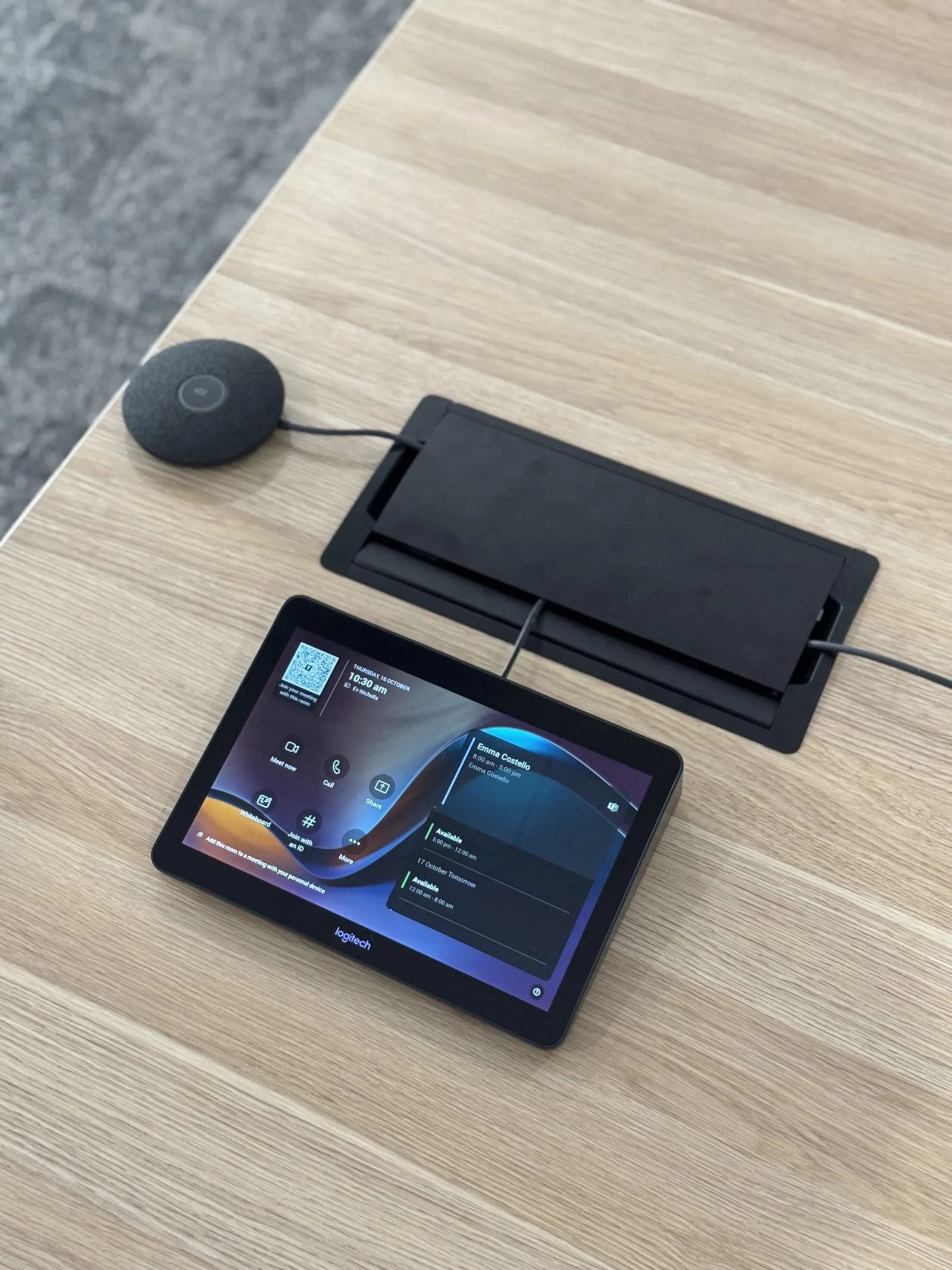 A Logitech touch console and table microphone pod on a RAAFA WA meeting table, with cable access hatch