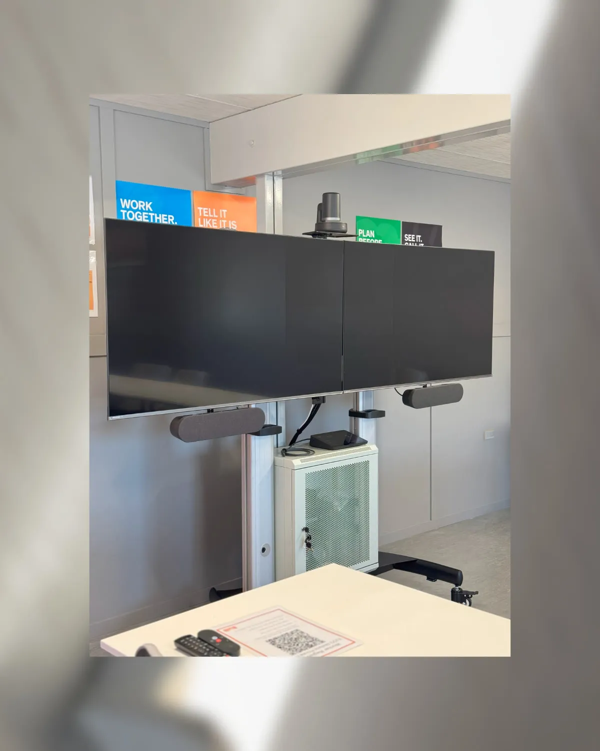 A mobile dual-display collaboration cart Focus AV built for construction company Built — PTZ camera on top, speakers and lockable equipment rack beneath