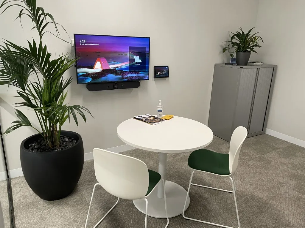 A small Focus AV huddle room — an all-in-one video bar beneath the wall display, round table for two or three