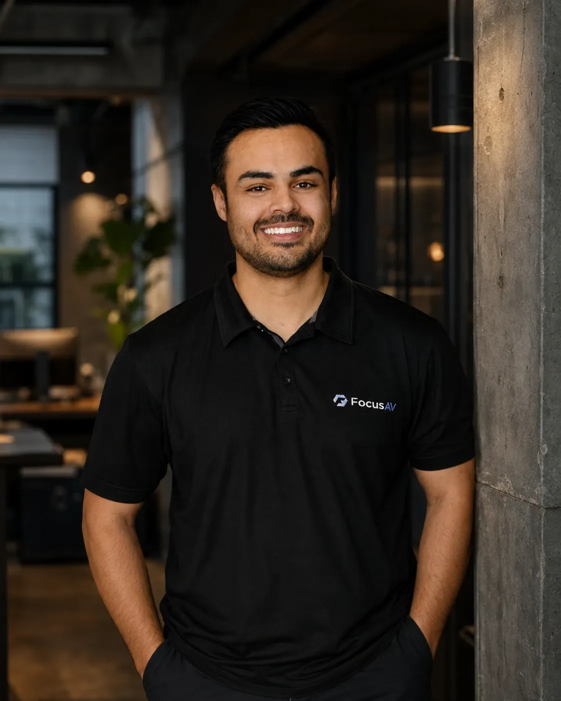 A Focus AV team member in a branded polo, in the open-plan office where a walkthrough starts