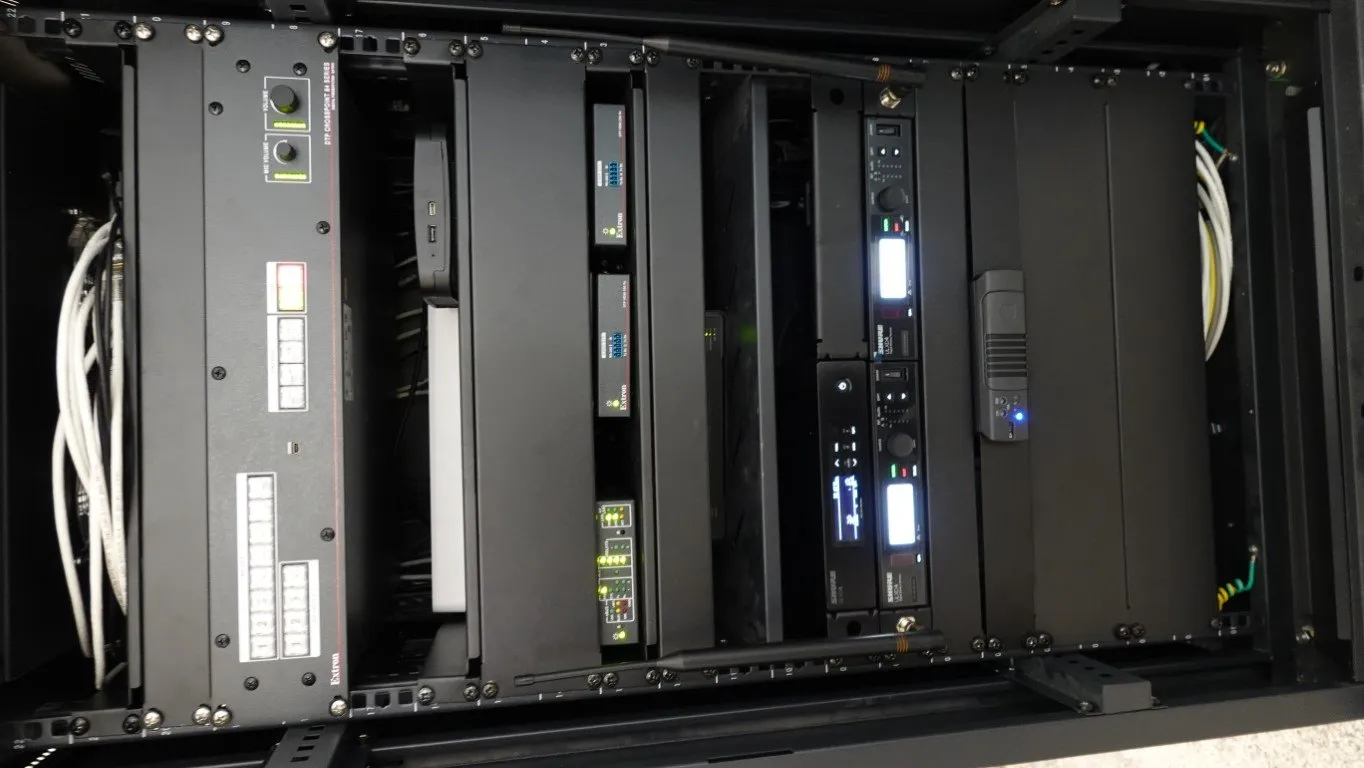 A populated AV rack of processing and routing hardware, cabled and labelled