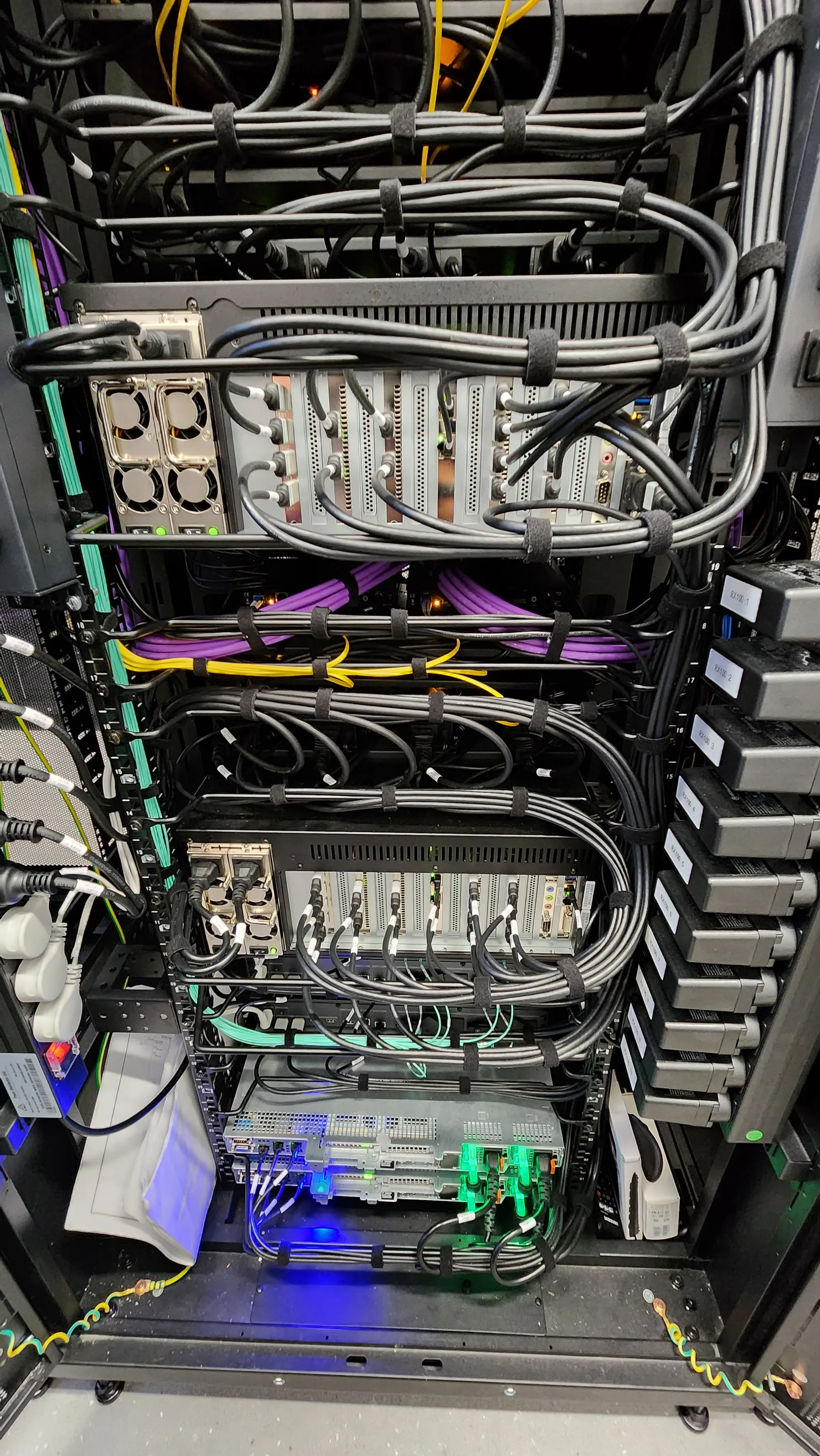 A close view of dense multicoloured cabling and indicator LEDs inside a populated rack