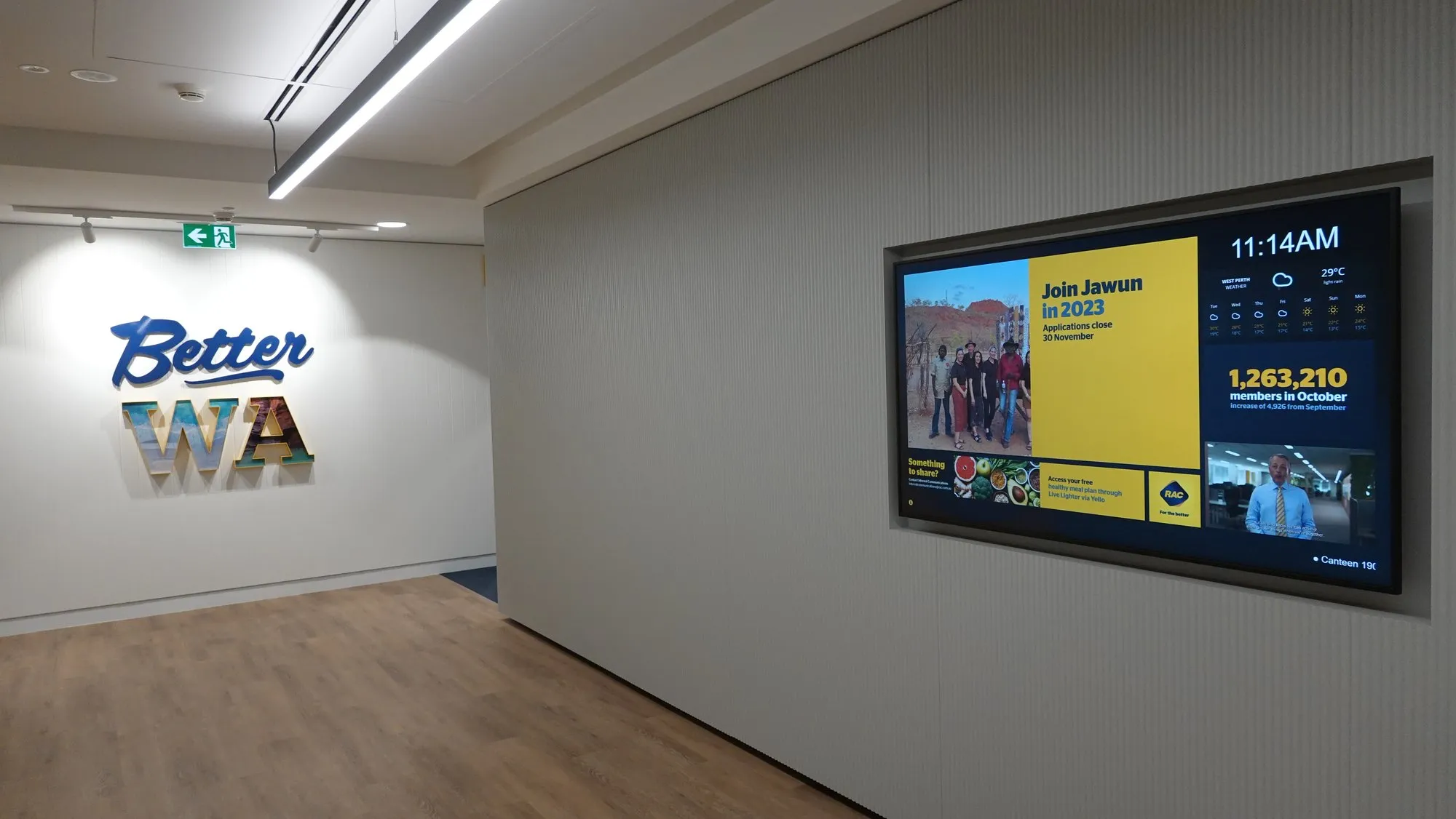 A corridor campaign screen beside the dimensional Better WA lettering in RAC's Perth workplace