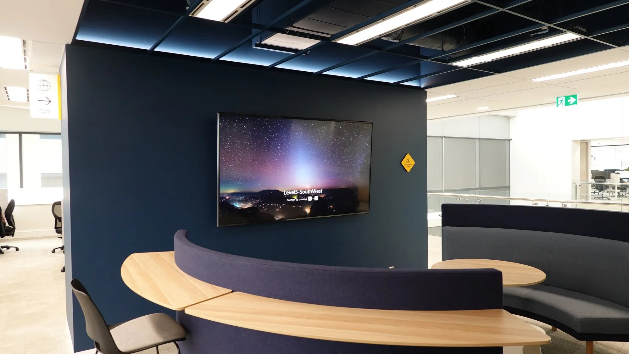 A curved banquette booth with an integrated wall display — AV-integrated furniture by Focus AV