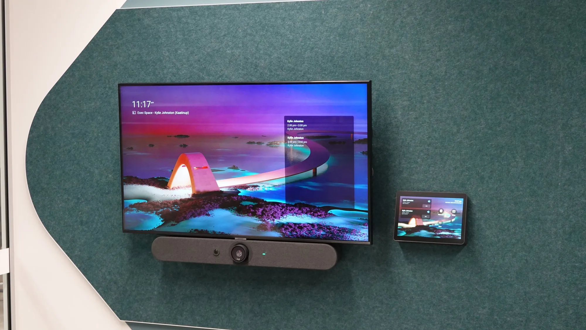 A certified video bar mounted below the display, with the touch controller on the table in front of it