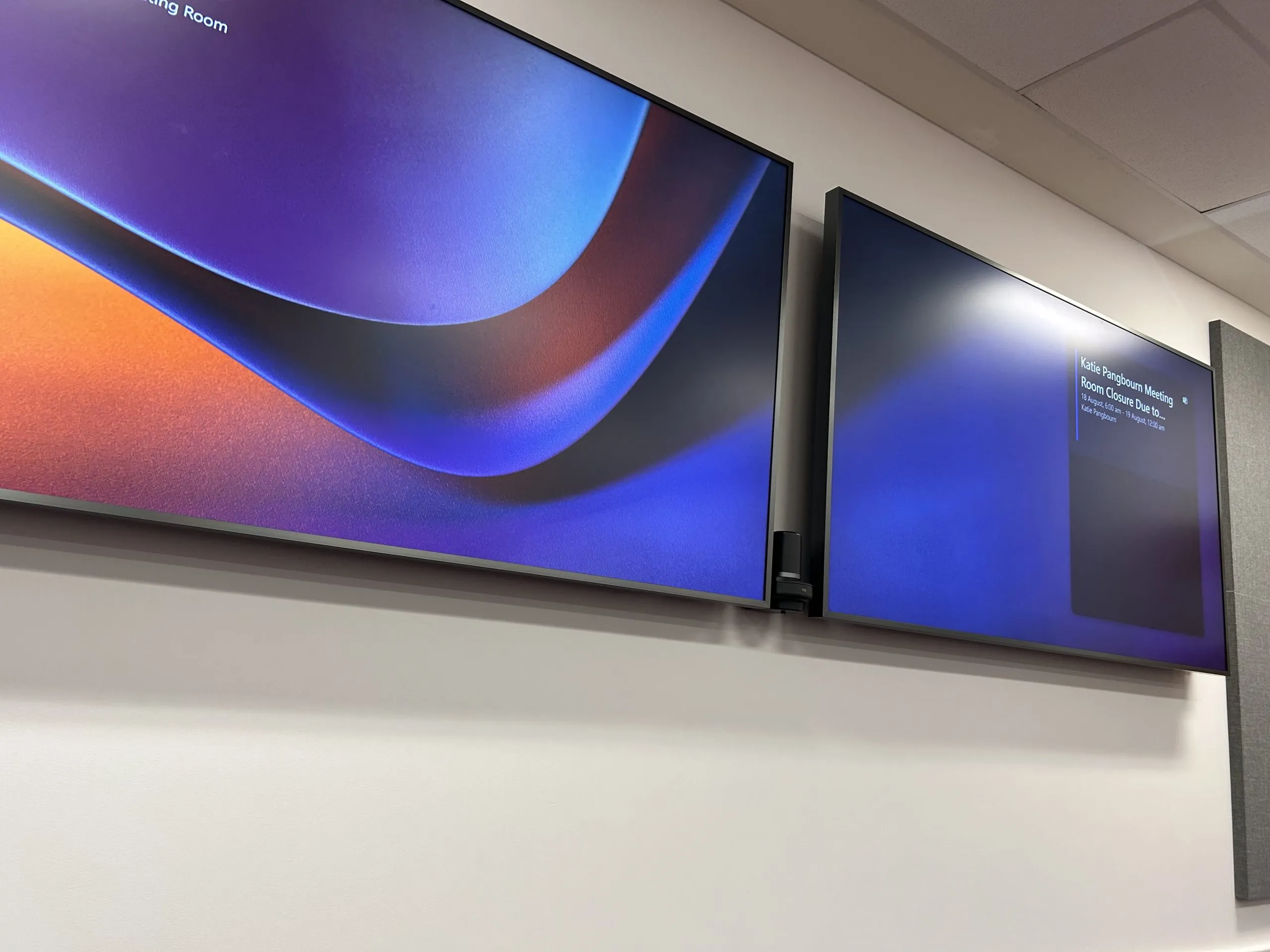 Wall display showing the Microsoft Teams standby graphic with room details