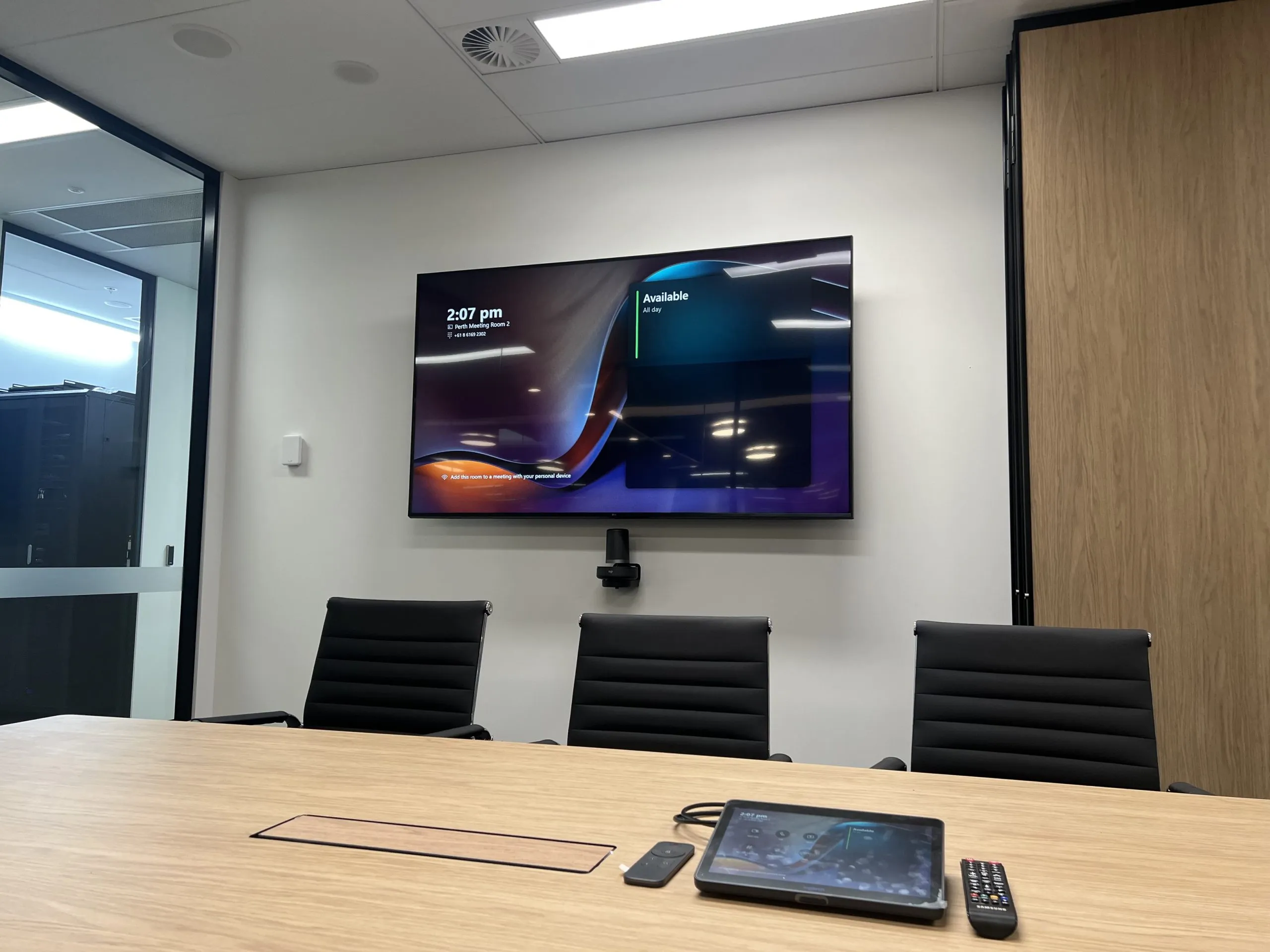 A mid-sized Focus AV Teams meeting room with a camera bar, touch console and ceiling microphone