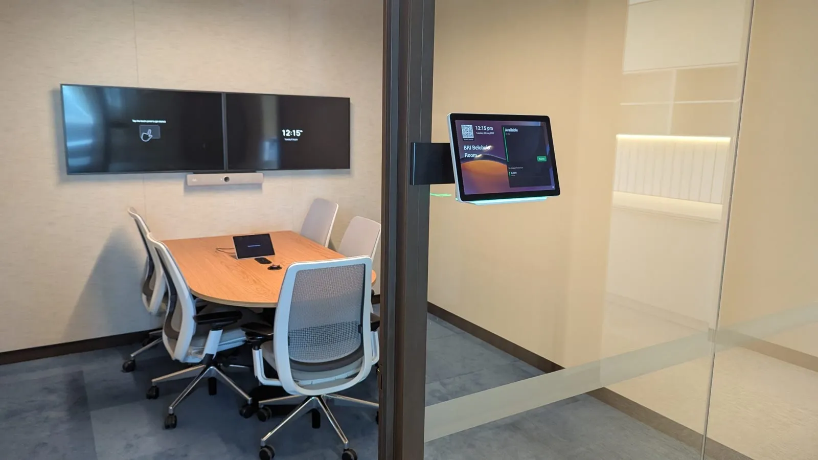 An open-plan floor at Newmont Australia's Perth workplace — rows of sit-stand desks and monitors beneath an exposed-services ceiling, glass meeting rooms along the far wall