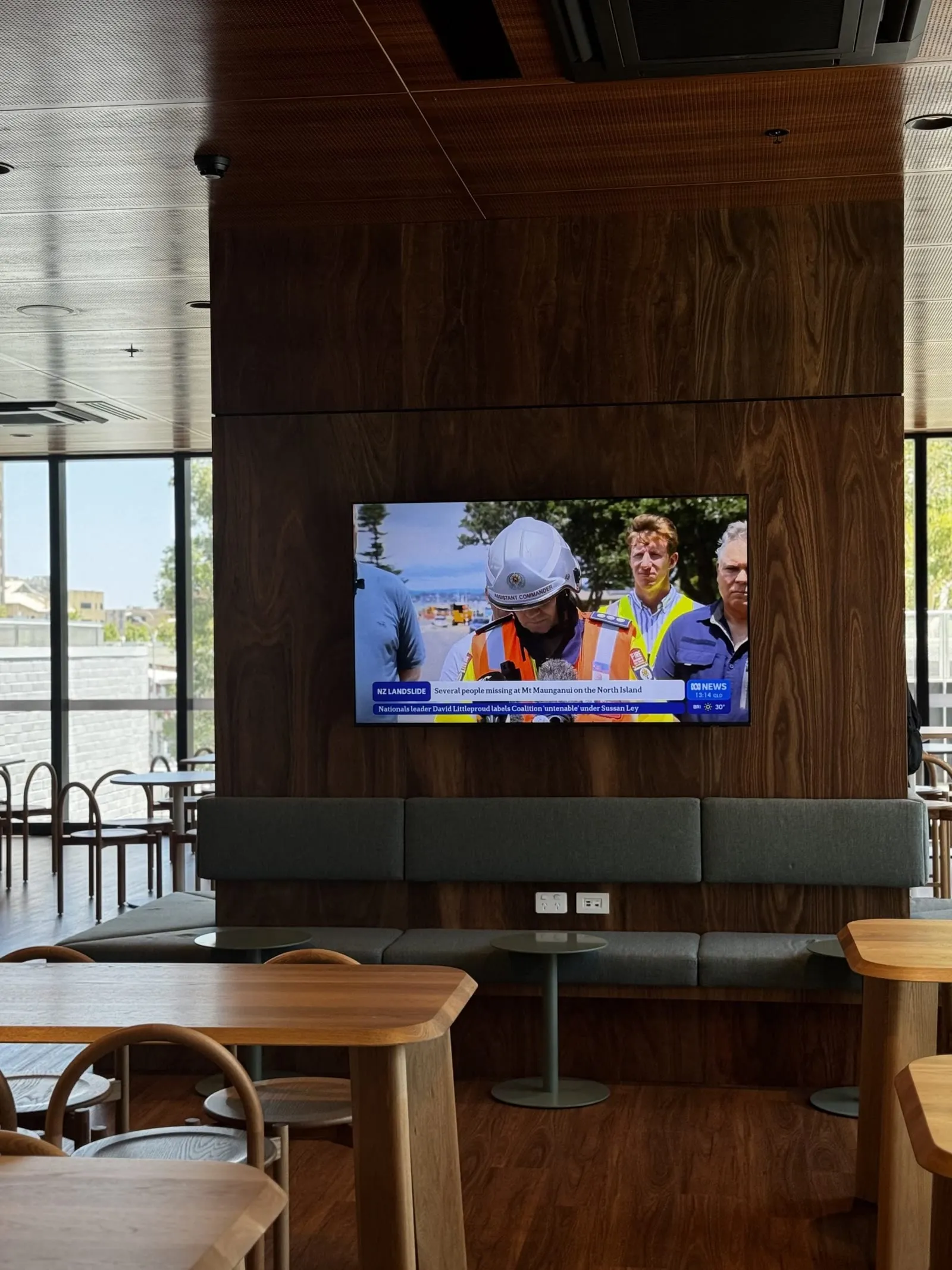 A staff dining area screen mixing live broadcast with the building's content channels