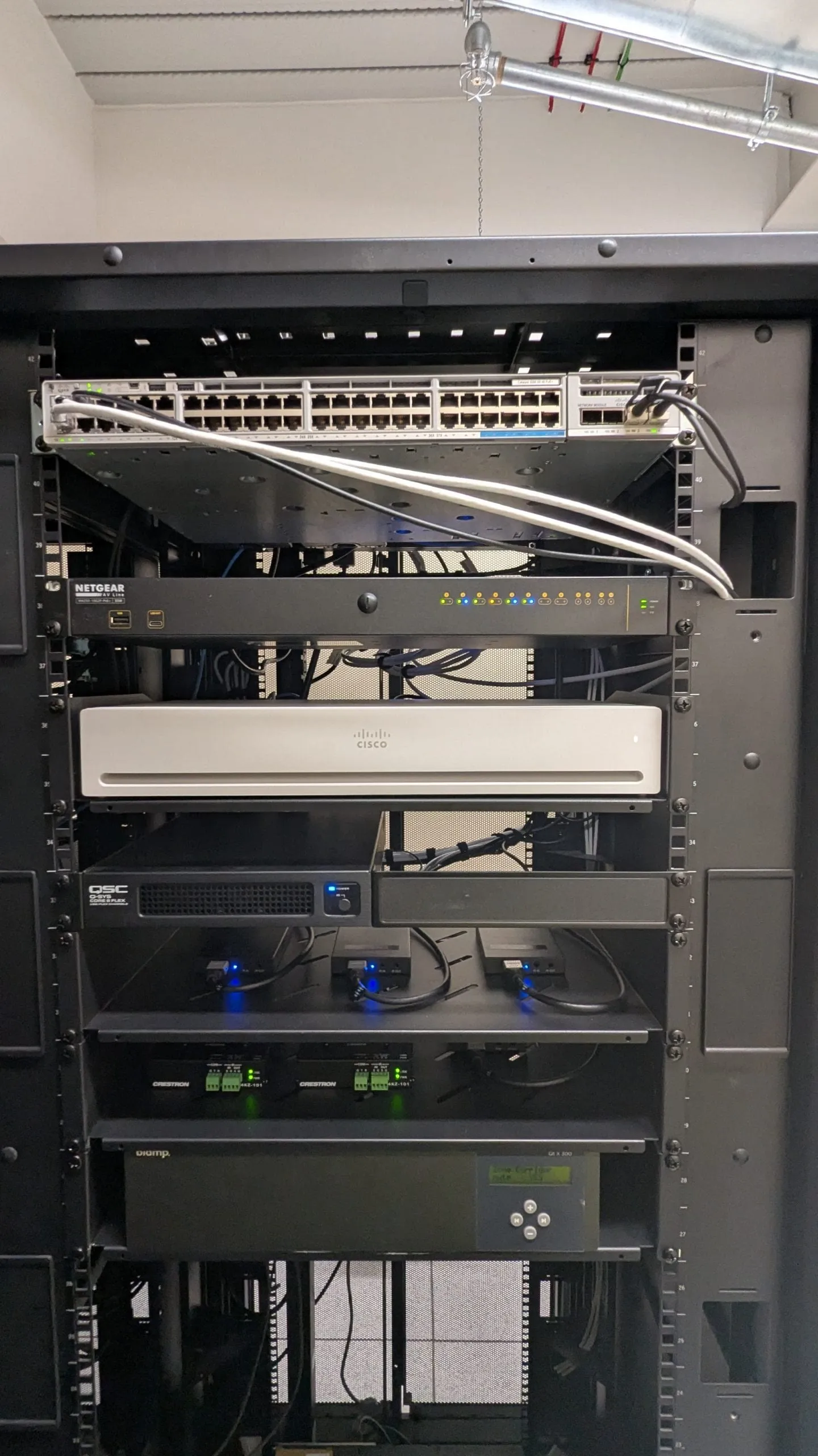 A labelled rack of network switching, audio processing and control hardware installed by Focus AV, built so individual components can be swapped without disturbing the rest