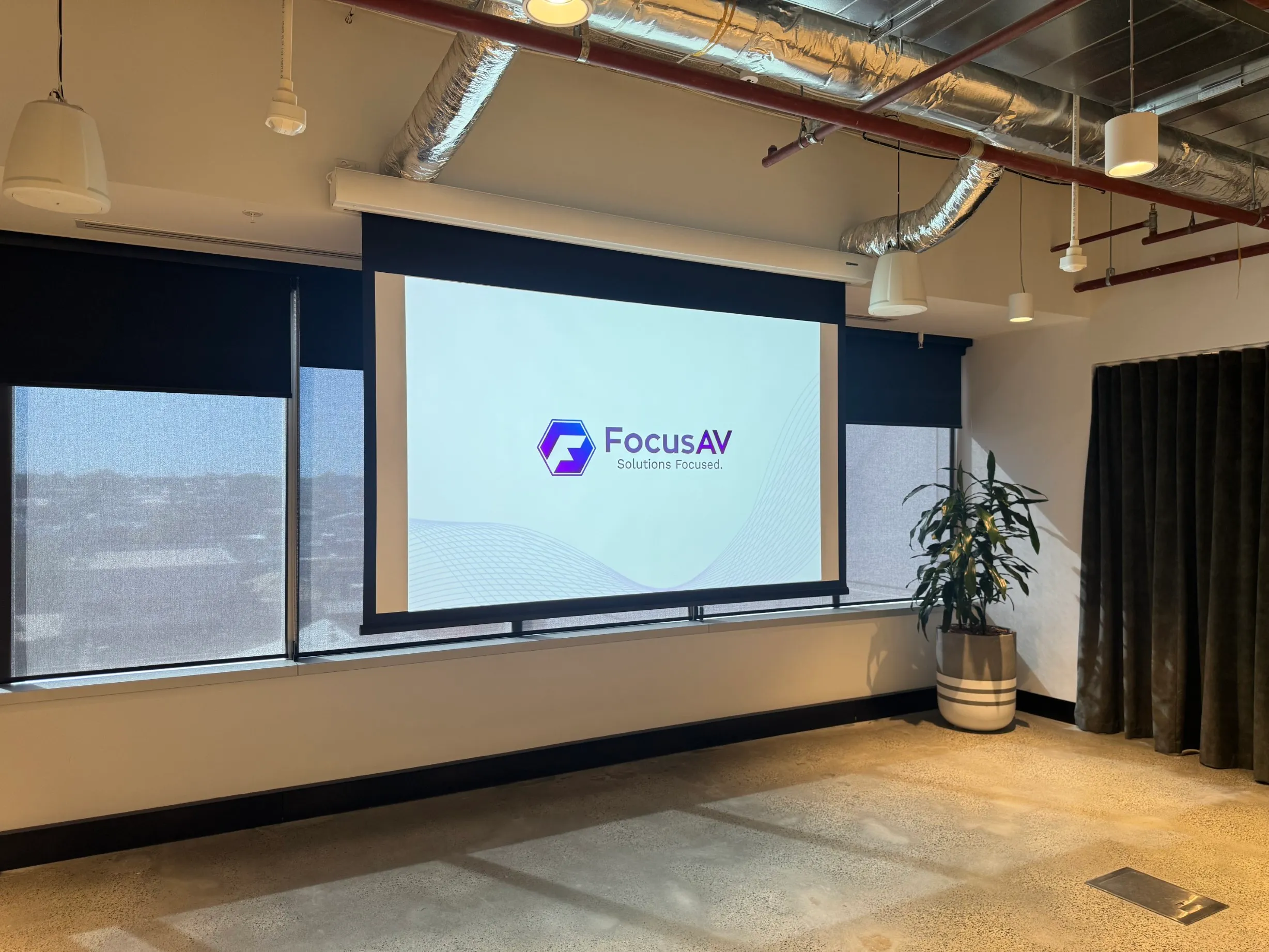 Projection screen on a Focus AV install showing the Solutions Focused tagline