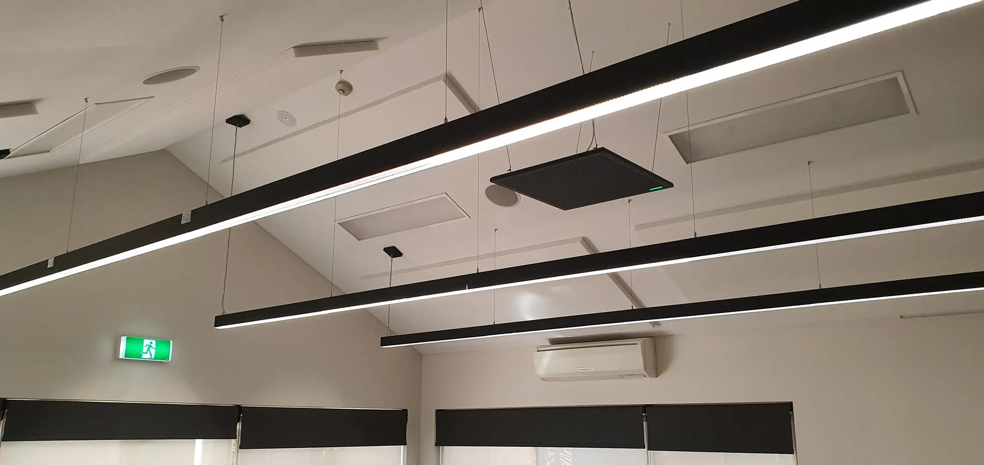 Suspended acoustic baffles hanging in rows from the ceiling of a Perth open-plan office