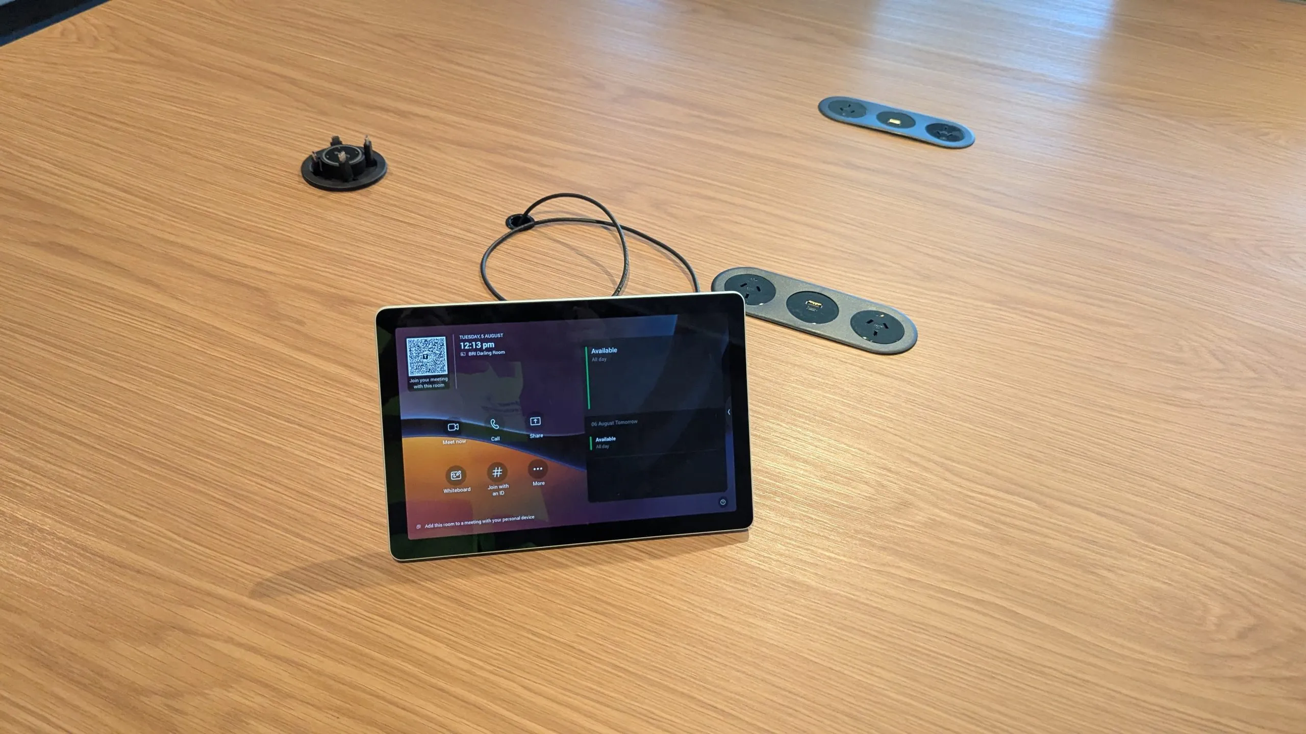 Teams room scheduling tablet on a boardroom table fitted out by Focus AV