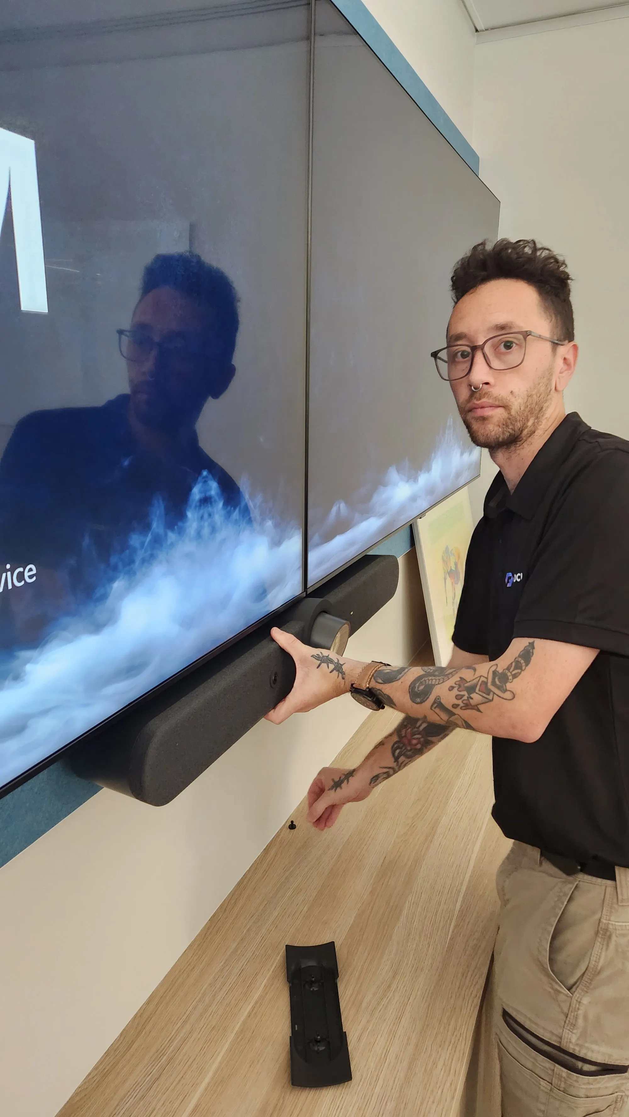 A Focus AV technician carrying a soundbar past a projection mid-install