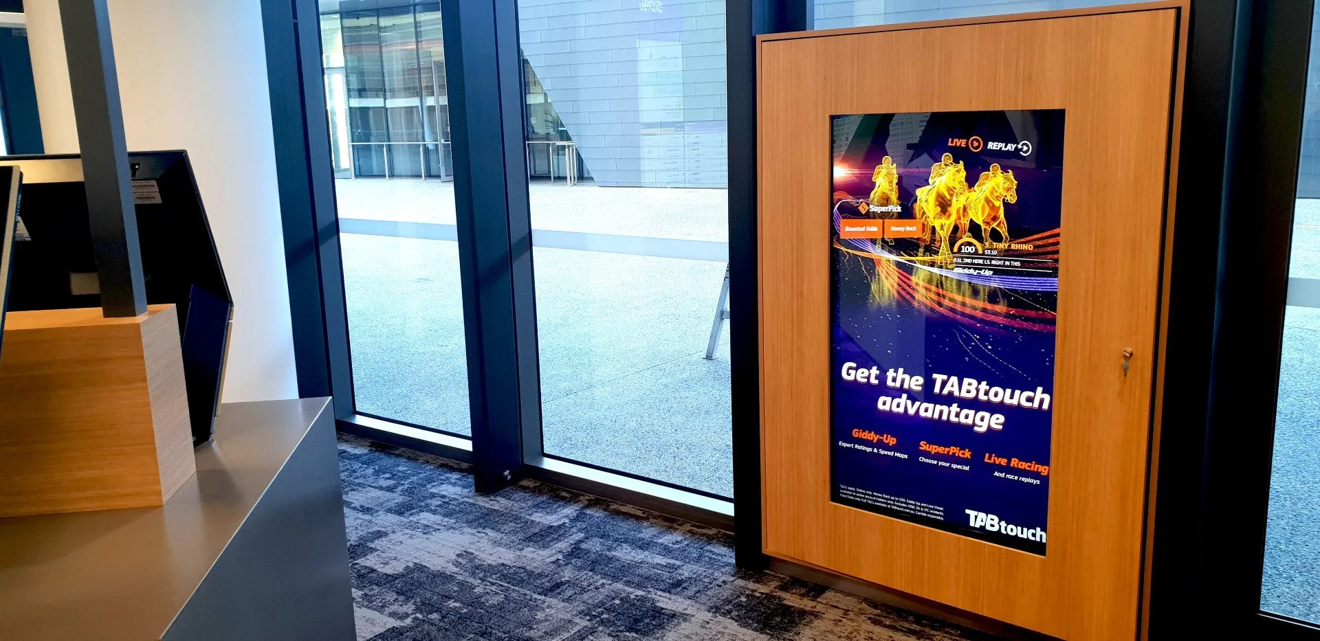 A timber-framed portrait totem running venue promotions beside the entry doors