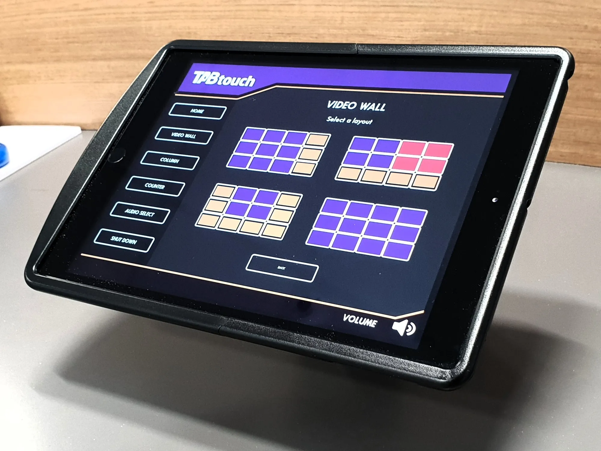 A tablet control panel showing a video wall layout selector with coloured screen groupings