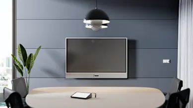 Logitech Rally Bar 65 all-in-one video conferencing system with built-in 65-inch display, mounted in a modern meeting room.